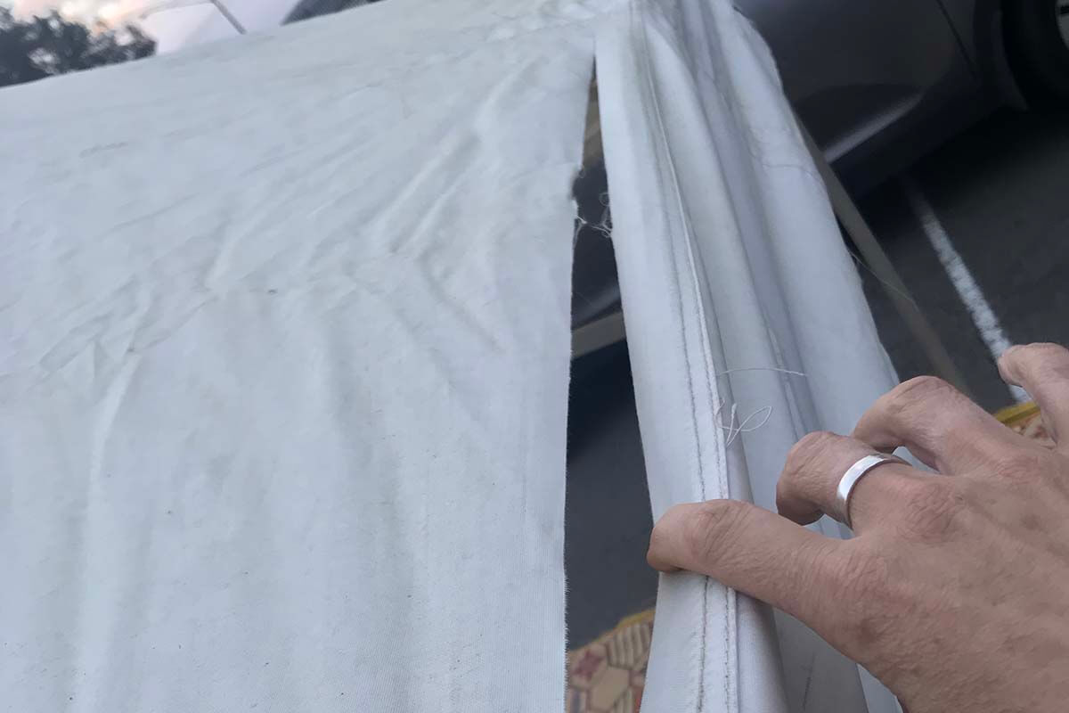 Polyester roof that's torn on a folding marquee